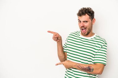 Beyaz arka planda izole edilmiş genç beyaz bir adam işaret parmağıyla fotokopi alanını işaret ederek heyecan ve arzusunu ifade ediyor..