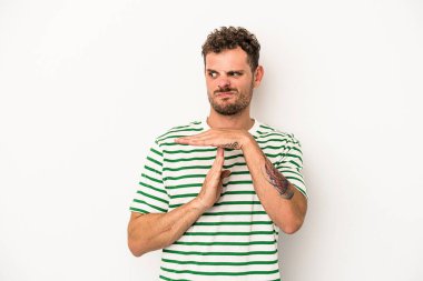 Beyaz arka planda izole edilmiş genç beyaz bir adam bir mola hareketi gösteriyor..