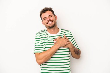 Beyaz arka planda izole edilmiş beyaz tenli genç bir adam, dostane bir ifadeye sahip, avuçlarını göğsüne bastırıyor. Aşk konsepti.