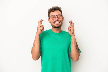 Beyaz arka planda izole genç beyaz adam şans dilemek için şans diliyor.