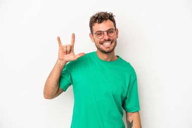 Beyaz arka planda izole edilmiş genç beyaz bir adam boynuzlarını devrim konsepti olarak gösteriyor..