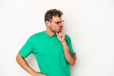 Beyaz arka planda izole edilmiş genç beyaz bir adam ya sır saklıyor ya da sessizlik istiyor..