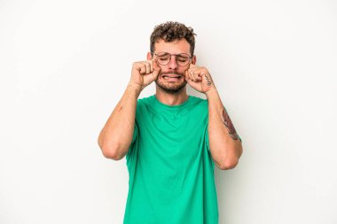 Beyaz arka planda ağlayan ve sızlanan beyaz tenli genç bir adam var..