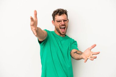 Beyaz arka planda izole edilmiş genç beyaz adam kameraya sarıldığı için kendinden emin hissediyor..