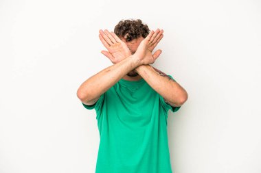 Beyaz arka planda izole genç beyaz adam iki kolu çapraz tutuyor, inkar kavramı.