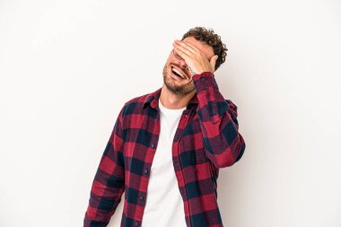 Beyaz arka planda izole olmuş genç beyaz bir adam ellerini başının üstünde tutarak neşeyle gülüyor. Mutluluk kavramı.