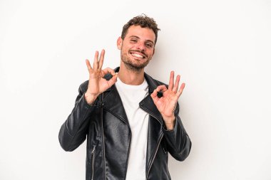 Beyaz arka planda izole edilmiş genç beyaz bir adam neşeli ve kendinden emin..