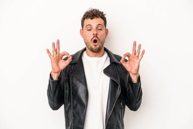 Beyaz arka planda izole edilmiş genç beyaz adam yoğun bir günün ardından rahatlıyor. Yoga yapıyor..