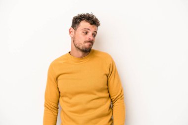 Beyaz arka planda izole edilmiş genç beyaz bir adam omuz silkiyor ve gözleri açık..