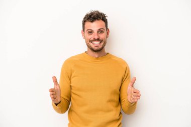 Beyaz arka planda izole edilmiş beyaz bir adam iki eliyle bir şey tutuyor..