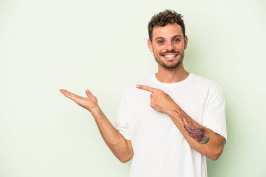 Kafkasyalı genç, yeşil arka planda izole edilmiş. Elinde bir fotokopi odası olduğu için heyecanlı..