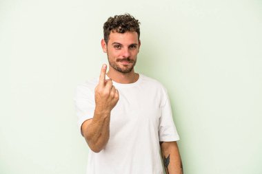 Yeşil arka planda izole edilmiş genç beyaz adam sanki seni davet ediyormuş gibi seni işaret ediyor..