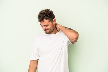 Genç, beyaz bir adam yeşil arka planda izole edilmiş. Durağan yaşam tarzından dolayı boyun ağrısı çekiyor..