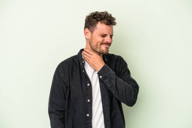 Yeşil arka planda izole edilmiş genç beyaz bir adam virüs veya enfeksiyon yüzünden boğazında ağrı hissediyor..