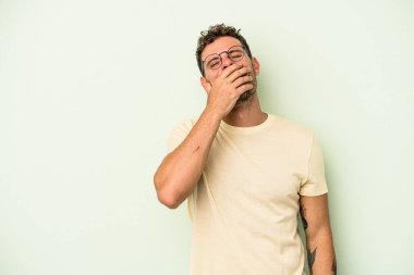 Yeşil arka planda izole edilmiş genç beyaz adam gülüyor, kaygısız, doğal duygu..