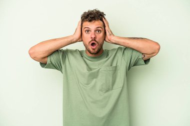 Yeşil arka planda izole genç beyaz adam şoka uğruyor, o önemli bir toplantı hatırlıyor.