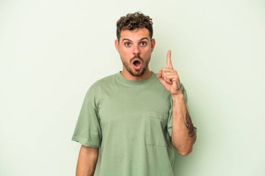 Yeşil arka planda izole edilmiş beyaz bir adam ağzı açık bir şekilde üst tarafı işaret ediyor..