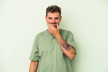 Kafkasyalı genç adam yeşil arka planda izole edildi. İki seçenek arasında şüphe var..