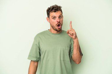 Kafkasyalı genç adam yeşil arka planda izole edilmiş. Harika bir fikri var. Yaratıcılık kavramı..