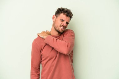 Yeşil arka planda izole edilmiş, omuz ağrısı olan genç beyaz bir adam..