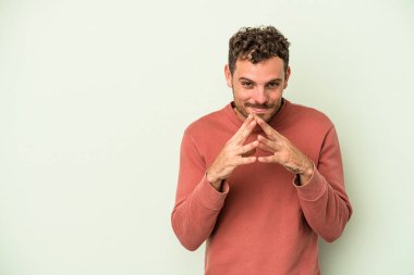 Kafkasyalı genç bir adam yeşil arka planda izole edilmiş bir plan yapıyor, bir fikir kuruyor..