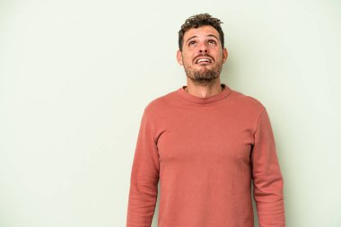 Kafkas 'lı genç adam yeşil arka planda izole edilmiş çok kızgın, öfkeli, hayal kırıklığına uğramış bağırıyor..