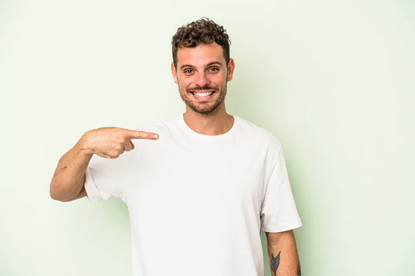 Mladý Běloch Izolovaný Zeleném Pozadí Osoba Ukazuje Ručně Košili Kopírovací — Stock fotografie