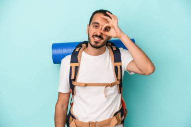 Beyaz atlı genç adam mavi arka planda izole edildi. Heyecanlı görünüyor..