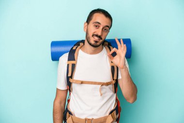 Beyaz atlı genç adam mavi arka planda izole edildi. Neşeli ve kendinden emin..