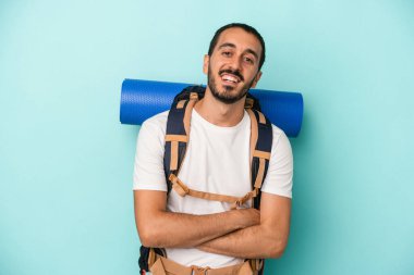 Beyaz atlı genç adam mavi arka planda izole edilmiş gülüyor ve eğleniyor..