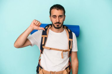 Beyaz atlı genç adam mavi arka planda izole edildi. Hoşlanmadığı bir hareket gösteriyor. Anlaşmazlık konsepti.