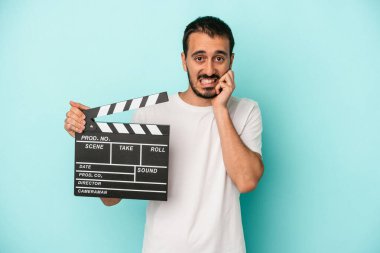 Kafkasyalı genç aktör elinde klaket tutuyordu. Mavi arka planda izole edilmiş, tırnaklarını yiyordu. Gergin ve endişeliydi..