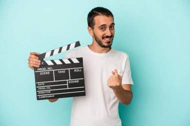 Kafkasyalı genç aktör elinde alçıpanla mavi arka planda izole edilmiş seni işaret ediyor sanki davet ediyormuş gibi..