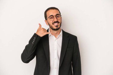 Beyaz arka planda izole edilmiş genç beyaz iş adamı parmaklarıyla bir cep telefonu hareketi gösteriyor..