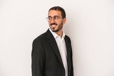 Beyaz arka planda izole edilmiş beyaz iş adamı gülümseyen, neşeli ve keyifli bir tarafa bakıyor..