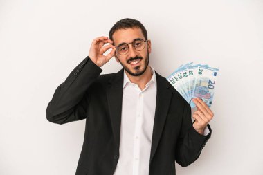 Beyaz arka planda izole edilmiş banknotlar tutan Kafkasyalı genç bir iş adamı..