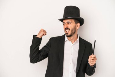 Beyaz arka planda asası olan genç sihirbaz zaferden sonra yumruğunu kaldırdı..