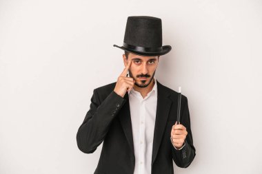 Beyaz arka planda asası olan genç sihirbaz parmağıyla tapınağı işaret ederek bir göreve odaklandı..