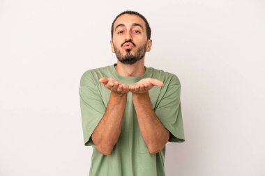 Beyaz arka planda izole edilmiş genç beyaz bir adam dudaklarını katlıyor ve hava öpücüğü vermek için avuç içleri tutuyor..