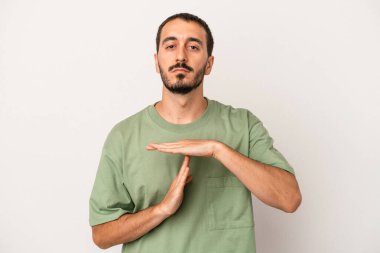 Beyaz arka planda izole edilmiş genç beyaz bir adam bir mola hareketi gösteriyor..