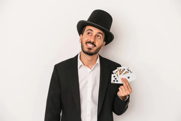 目標と目的を達成する夢の白い背景に隔離された魔法のカードを持っている若い魔術師の男 — ストック写真