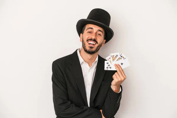白い背景に孤立した魔法のカードを持っている若い魔術師の男は笑って楽しい — ストック写真