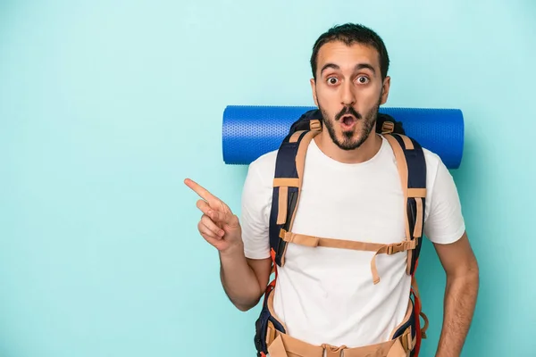 Jovem Homem Caminhante Caucasiano Isolado Fundo Azul Apontando Para Lado — Fotografia de Stock