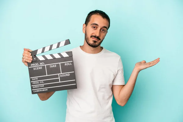 Młody Biały Aktor Mężczyzna Trzymając Klapperboard Odizolowany Niebieskim Tle Pokazując — Zdjęcie stockowe