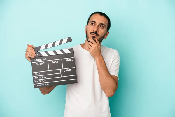 Młody Biały Aktor Człowiek Trzymając Clapperboard Odizolowany Niebieskim Tle Patrząc — Zdjęcie stockowe