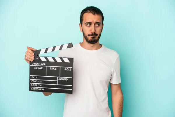 Young Caucasian Actor Man Holding Clapperboard Isolated Blue Background Confused — Stock Photo, Image