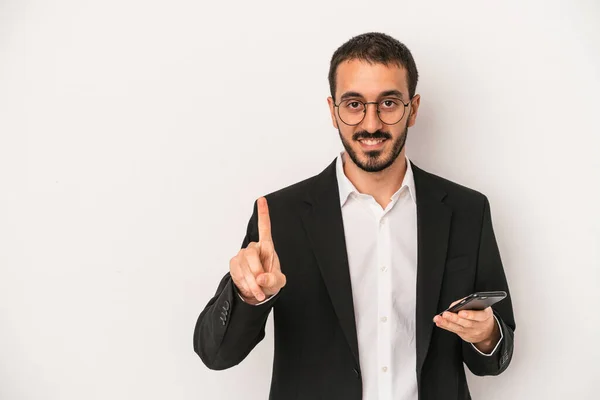 Mladý Podnikatel Drží Mobilní Telefon Izolovaný Bílém Pozadí Ukazující Číslo — Stock fotografie