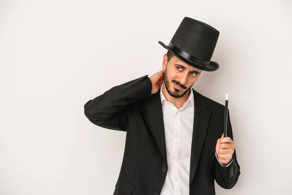 頭の後ろに触れ 思考し 選択をする白い背景に隔離された杖を持つ若い魔術師の男 — ストック写真