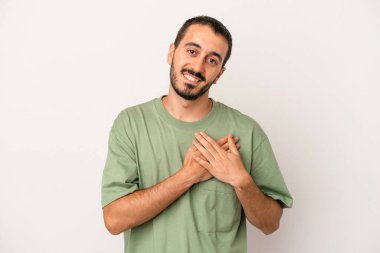 Beyaz arka planda izole edilmiş beyaz tenli genç bir adam, dostane bir ifadeye sahip, avuçlarını göğsüne bastırıyor. Aşk konsepti.