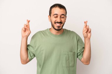 Beyaz arka planda izole genç beyaz adam şans dilemek için şans diliyor.